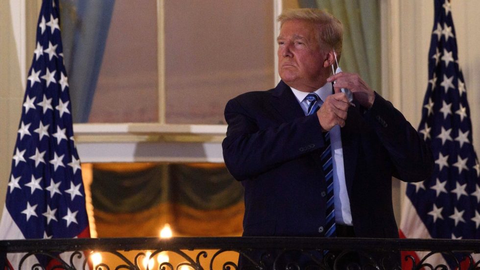 Trump tira a máscara e ergue o polegar ao chegar à Casa Branca